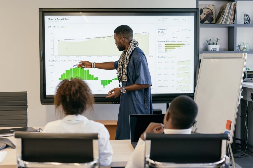 Engaging business presentation featuring data analysis on a large monitor.